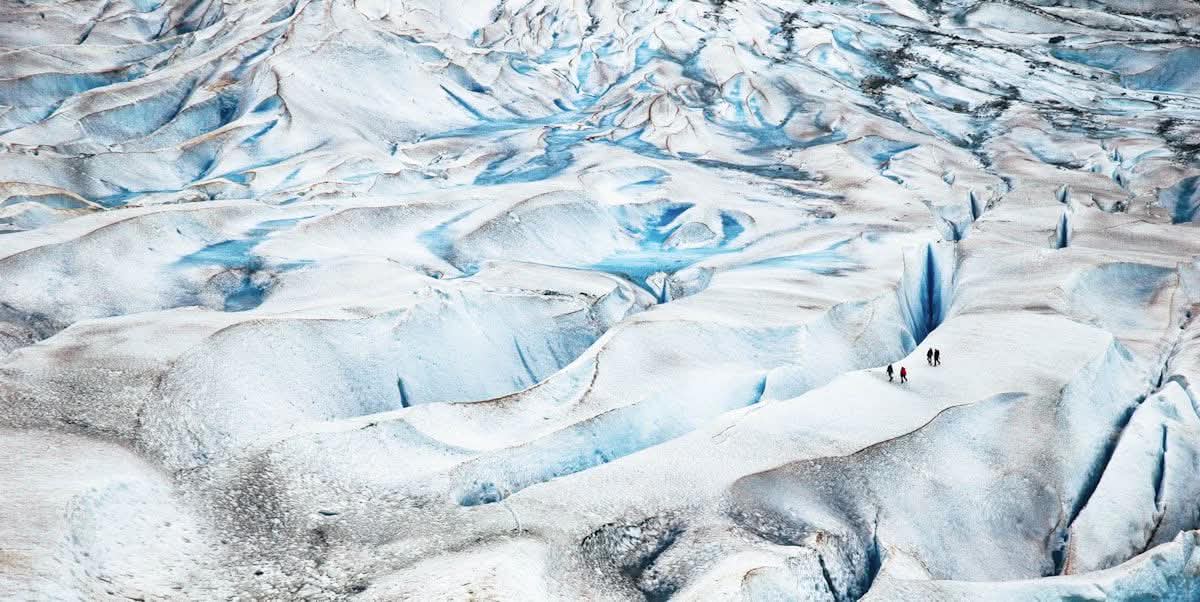 Trekkers crossing the blue crevasses of Mendenhall Glacier near Juneau, Alaska
