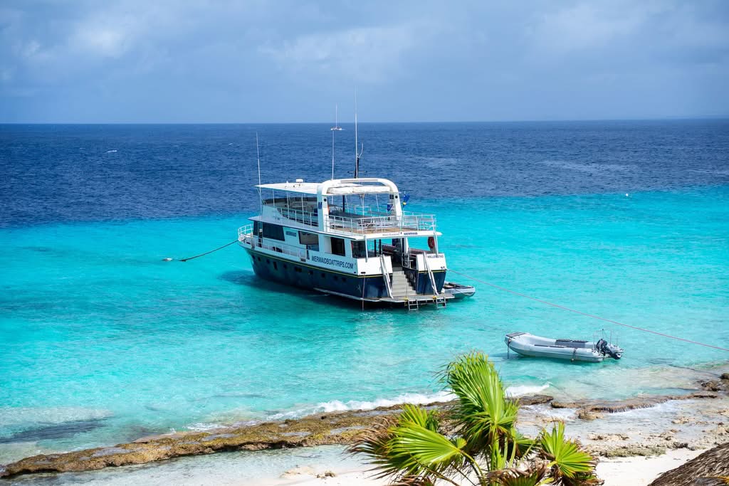 Explore the serene beauty of a tour boat anchored on the vibrant turquoise waters of Curaçao
