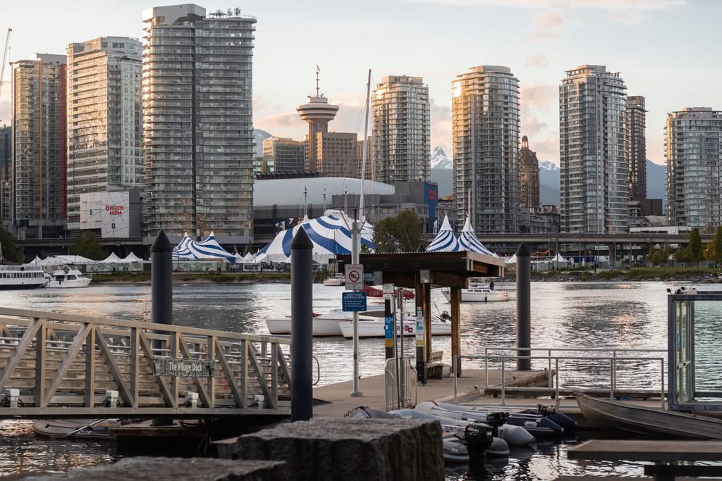 Scenic view of Vancouver's skyline reflecting on water during golden hour, captured from Village Dock