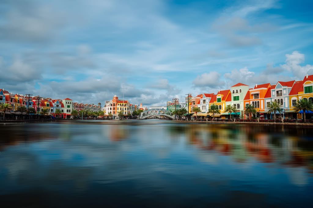 Vibrant European-style buildings along a calm waterfront in Phu Quoc, Vietnam, under a bright sky