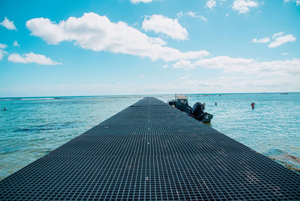Serene pier stretching into the ocean under a bright blue sky in Mahahual, Mexico