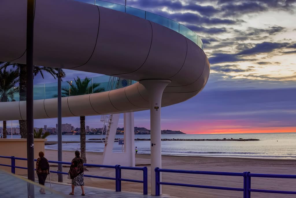 Peaceful Alicante beach promenade during sunset with modern architecture