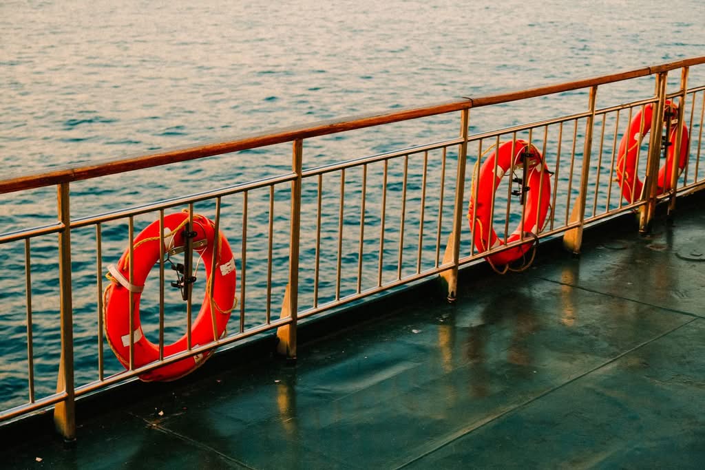 View of ship deck with lifebuoys and calm sea, capturing serene ocean travel