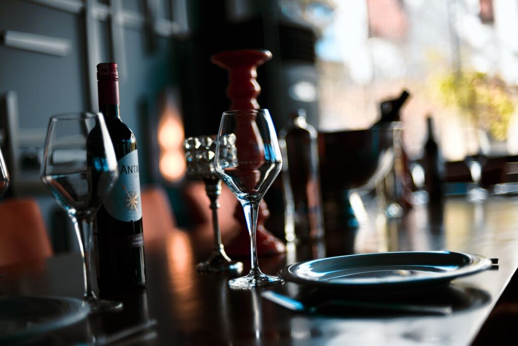 A sophisticated indoor wine setting with glasses, a bottle, and warm lighting