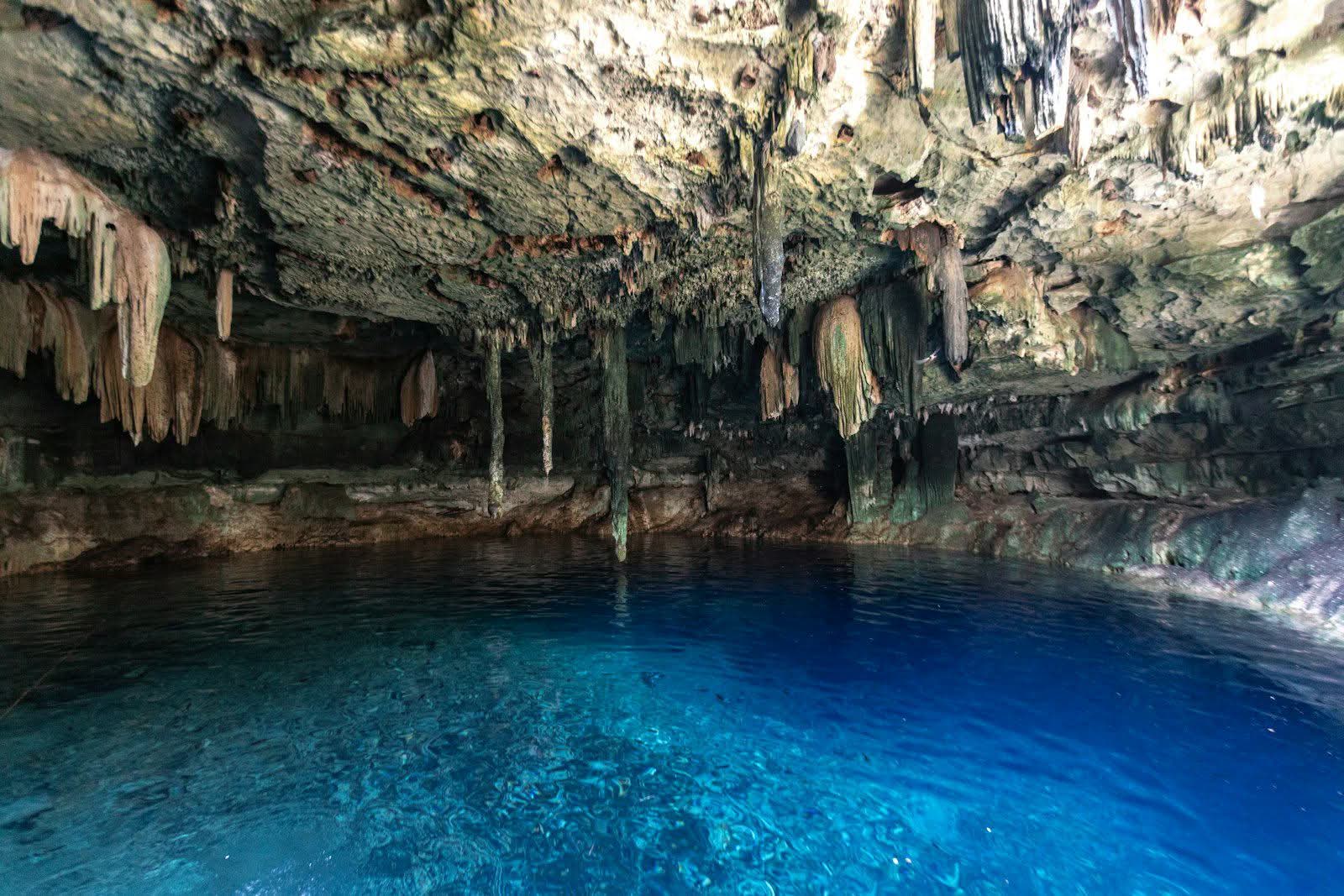 Shafts of light over the blue water of a cavern cenote in the Yucatán