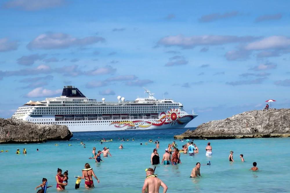 Cruise ship anchored off a turquoise Caribbean swimming cove