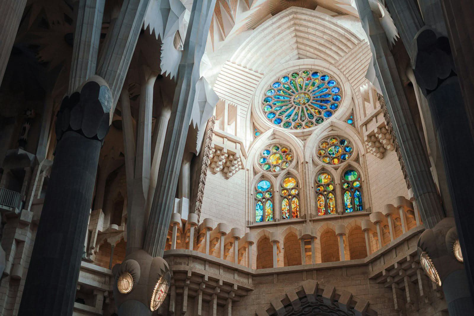 Stained-glass light flooding the stone columns inside the Sagrada Família